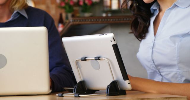 Coworkers using tablet and laptop at shared workspace - Download Free Stock Images Pikwizard.com