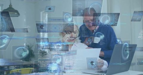 Senior Couple Analyzing Documents in Modern Workspace with Digital Overlays