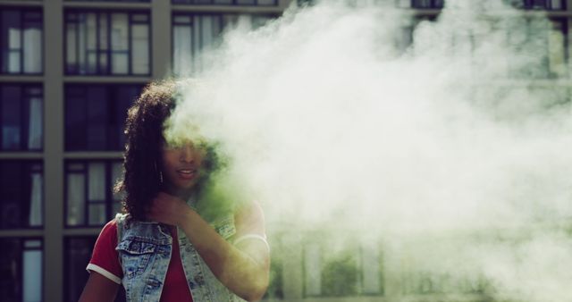 Biracial trendy woman holding smoke grenade on roof in city with copy space, unaltered - Download Free Stock Photos Pikwizard.com