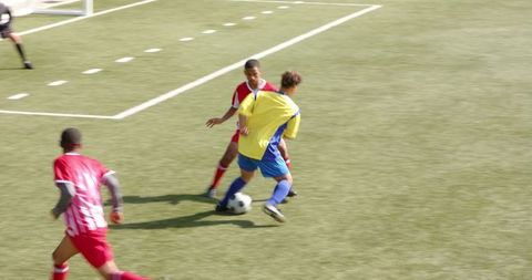 Youth soccer players competing during intense game on field