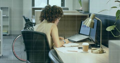 Focused Businesswoman Analyzing Charts at Workspace with Wheelchair