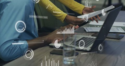 Business Professionals Analyzing Data on Laptop with Digital Graphics
