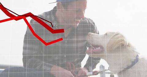 Kneeling man with retriever leash smiling in backlit scene with declining red graph