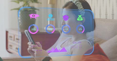 Korean woman using smartphone while viewing augmented reality finance dashboard on sofa