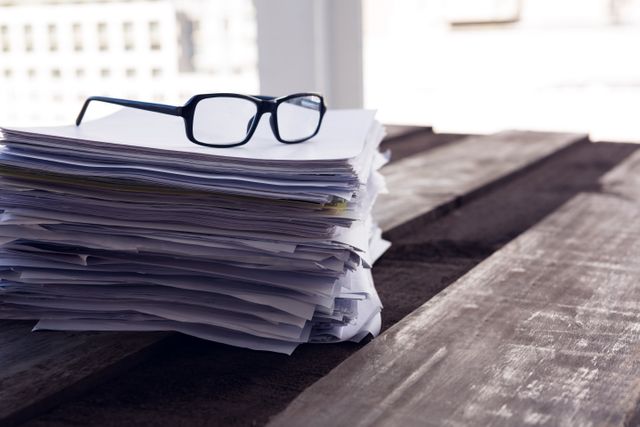 Close-up of spectacles on documents at desk