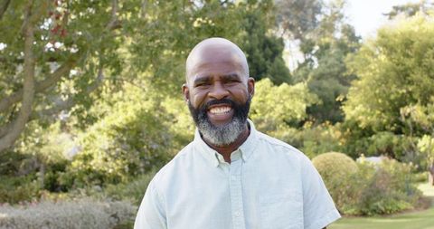 Joyful man enjoying nature walking through lush garden
