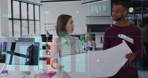 Designers collaborating over blueprint holding plans while displaying augmented charts