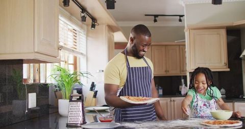 Father and Daughter Making Pizza Together in Kitchen
