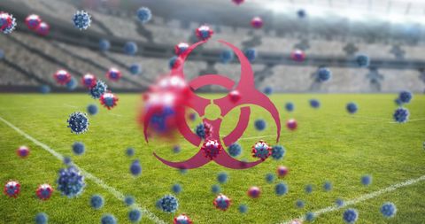 Coronavirus cells and biohazard symbol over empty stadium