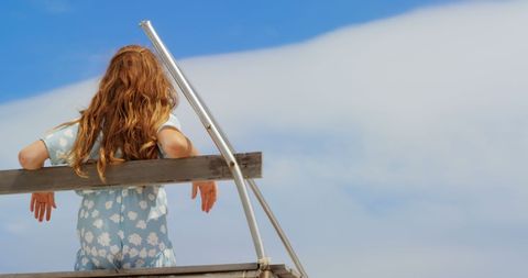 Woman Relaxing on Beach Tower Gazing at Sea