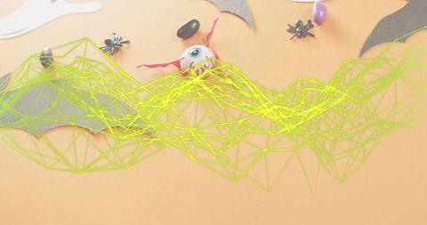 Neon wireframe web overlay on halloween flatlay featuring bats spiders eyeball candy mesh