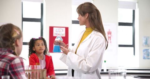 Female Science Teacher Demonstrating Chemistry Experiment in Classroom