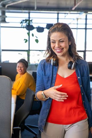 Smiling diverse female coworkers collaborating in modern open-plan office