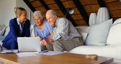 Senior couple consulting with realtor in cozy living room
