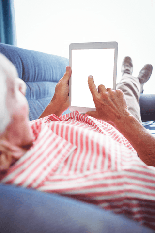 elderly man using tablet interface transparent screen relaxing on sofa - Download Free Stock Videos Pikwizard.com