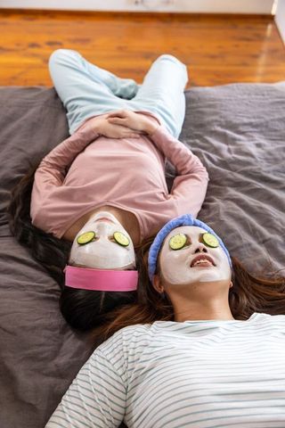 Mother and Daughter Enjoying Relaxing Home Spa Day with Facemasks