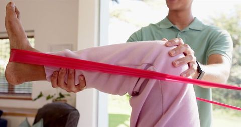 Senior Woman Engaging in Leg Exercise with Physiotherapist Assistance