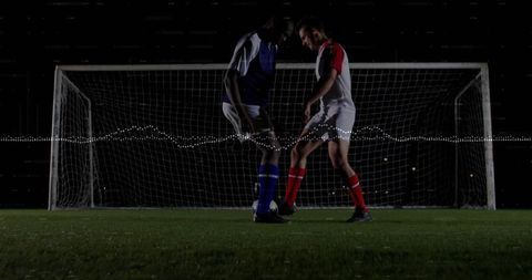 Intense Soccer Duel Under Stadium Lights in Night Match
