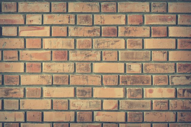 Vintage brick wall texture displaying reddish-brown bricks with variations and weathering. Ideal for use as a background in design projects, advertisements, or websites. Great for adding a rustic or retro aesthetic to any digital or physical space.
