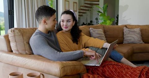Couple Relaxing on Sofa with Laptop in Cozy Living Room Interior