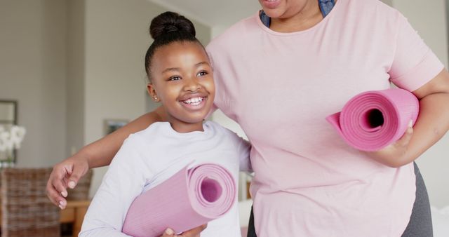 Mother and Daughter Smiling Holding Yoga Mats at Home - Download Free Stock Images Pikwizard.com