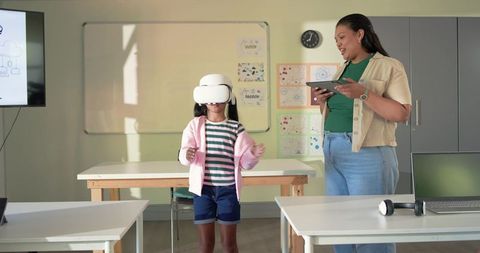 African American Teacher Guiding Child Using VR Headset for Classroom STEM Learning