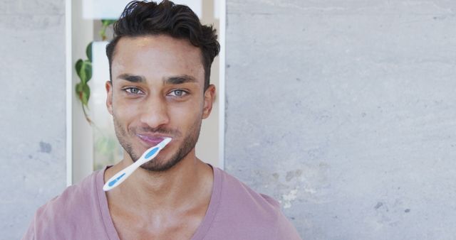 Young Man Brushing Teeth Smiling Wearing Pink V-Neck - Download Free Stock Images Pikwizard.com