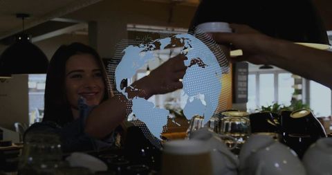 Female customer receiving takeaway coffee at modern cafe with dotted global network overlay