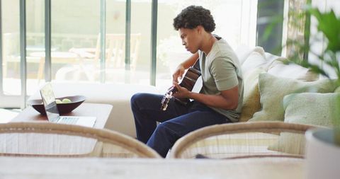Man Playing Guitar and Using Laptop at Home - Download Free Stock Images Pikwizard.com
