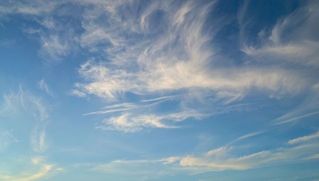 Serene Wispy Clouds Against Vast Blue Sky in Stunning Panorama
