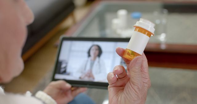 Senior Person Consulting Doctor via Video Call Holding Prescription Bottle - Download Free Stock Images Pikwizard.com