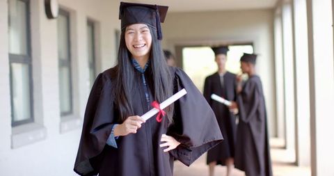 Joyful Asian Graduate Celebrating Achievement with Diploma in Hand - Download Free Stock Images Pikwizard.com