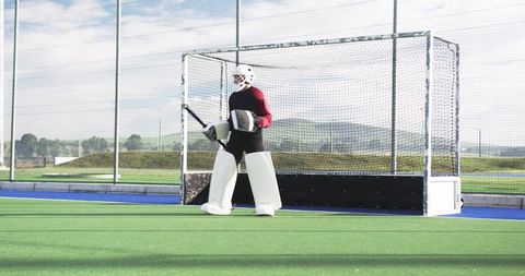 Teen Boy Field Hockey Goalie Standing on Turf Ready to Defend Net