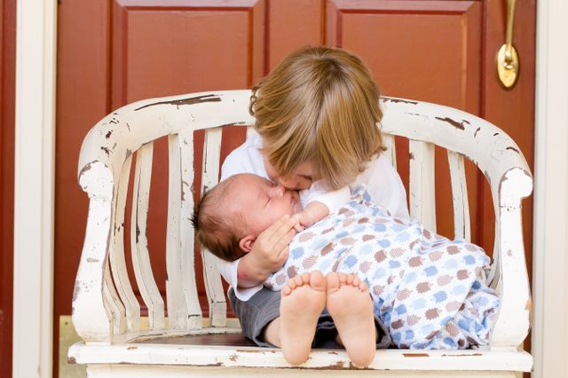 Adorable Sibling Bond: Brother Kissing Newborn on Old Bench - Download Free Stock Photos Pikwizard.com