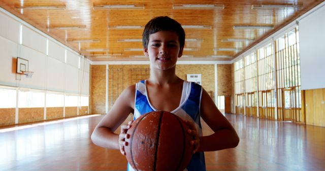 Young Boy Holding Basketball in Empty Gymnasium - Download Free Stock Images Pikwizard.com