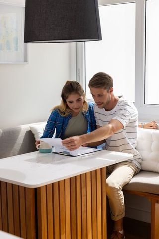 Couple collaborating in cozy dining nook with documents