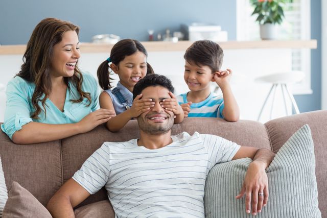 Girl covering her father eyes while giving surprise in living room - Download Free Stock Photos Pikwizard.com