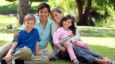 Happy Family Relaxing Together in Sunny Park Landscape