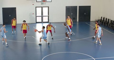 Intense Basketball Game Action on Blue Indoor Court