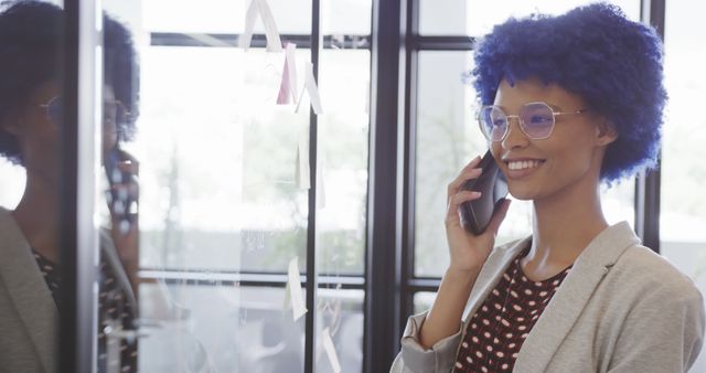 Confident Businesswoman with Blue Curly Hair on Phone Call in Modern Office - Download Free Stock Images Pikwizard.com