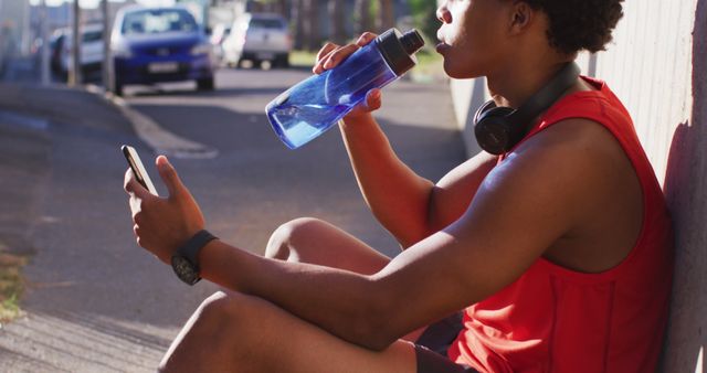 Athletic Man Relaxing with Water Bottle and Smartphone After Workout - Download Free Stock Images Pikwizard.com