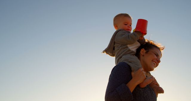 Smiling Mother Carrying Baby on Shoulders Outdoors - Download Free Stock Images Pikwizard.com