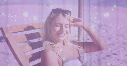 Happy woman sunbathing on beach with magical lighting effect