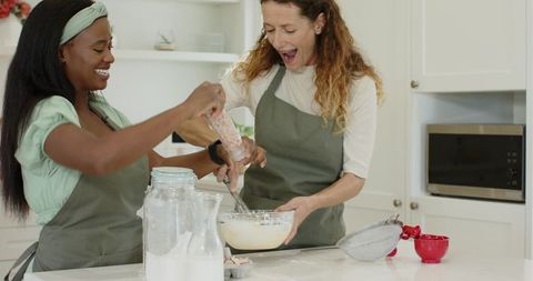 Diverse Friends Enjoy Baking Together at Home with Joyful Expressions