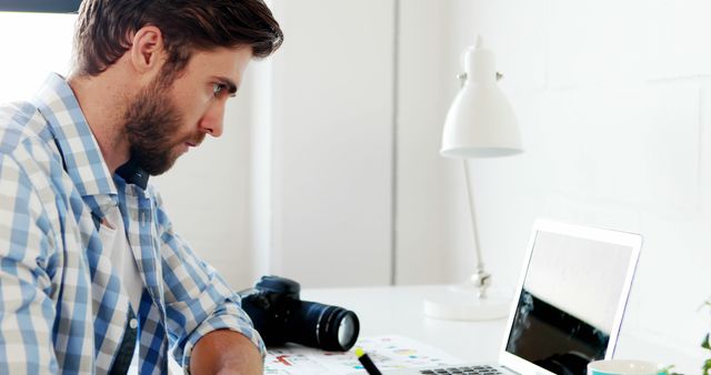 Focused Photographer Editing Photos on Laptop at Desk - Download Free Stock Images Pikwizard.com