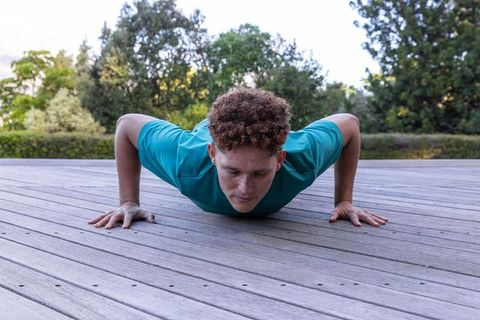 Man Exercising Outdoors with Push-ups on Wooden Deck