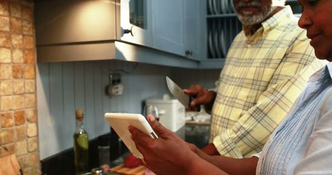 Senior Couple Cooking Together With Digital Assistance