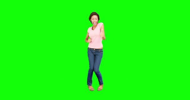 Woman standing and smiling while dancing in casual attire with green screen background. Suitable for use in promotional materials, advertisements, presentations, and video compositing where you need to superimpose the person onto different backgrounds.