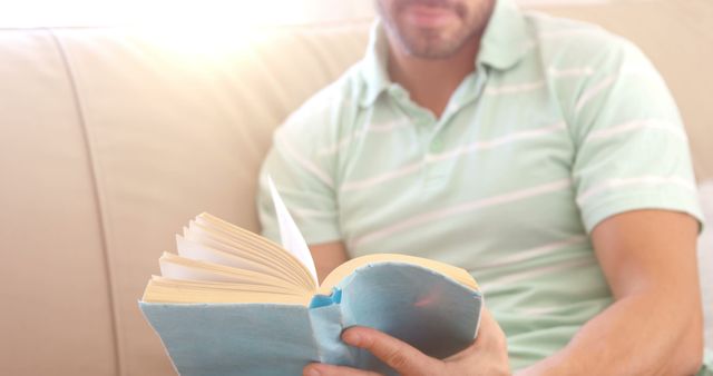 Man Relaxing on Couch Reading a Book at Home - Download Free Stock Images Pikwizard.com