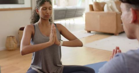African american couple meditating together at home on blue yoga mat for mindfulness